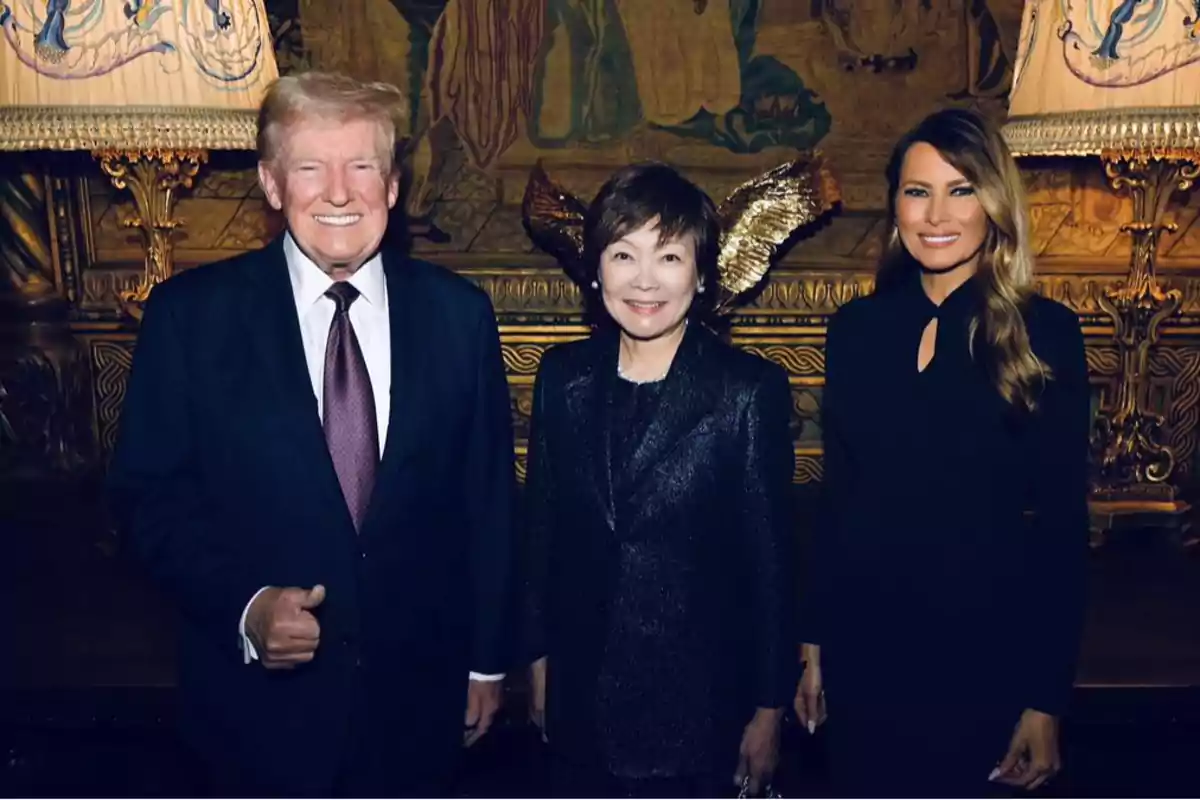 Tres personas posan juntas en un ambiente elegante con una decoración de fondo detallada.