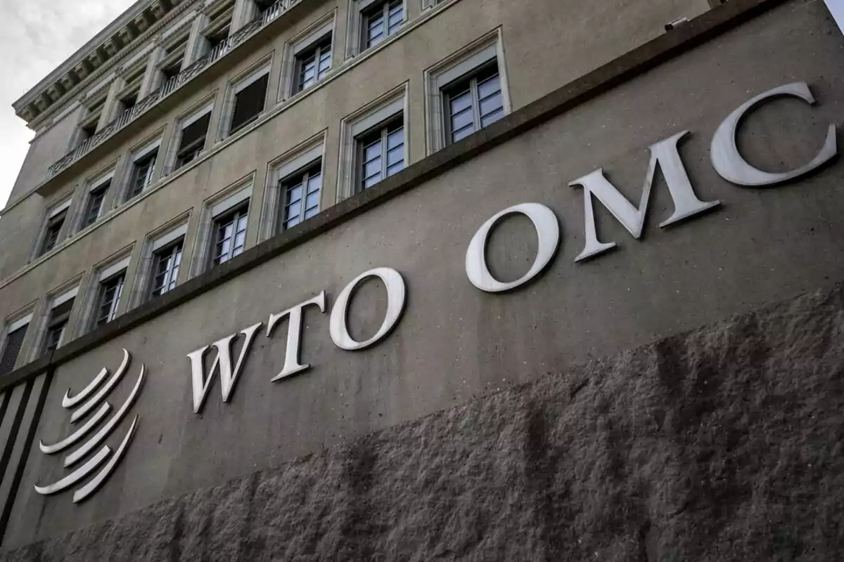 Edificio de la Organización Mundial del Comercio con el logo y las siglas WTO OMC en la fachada.