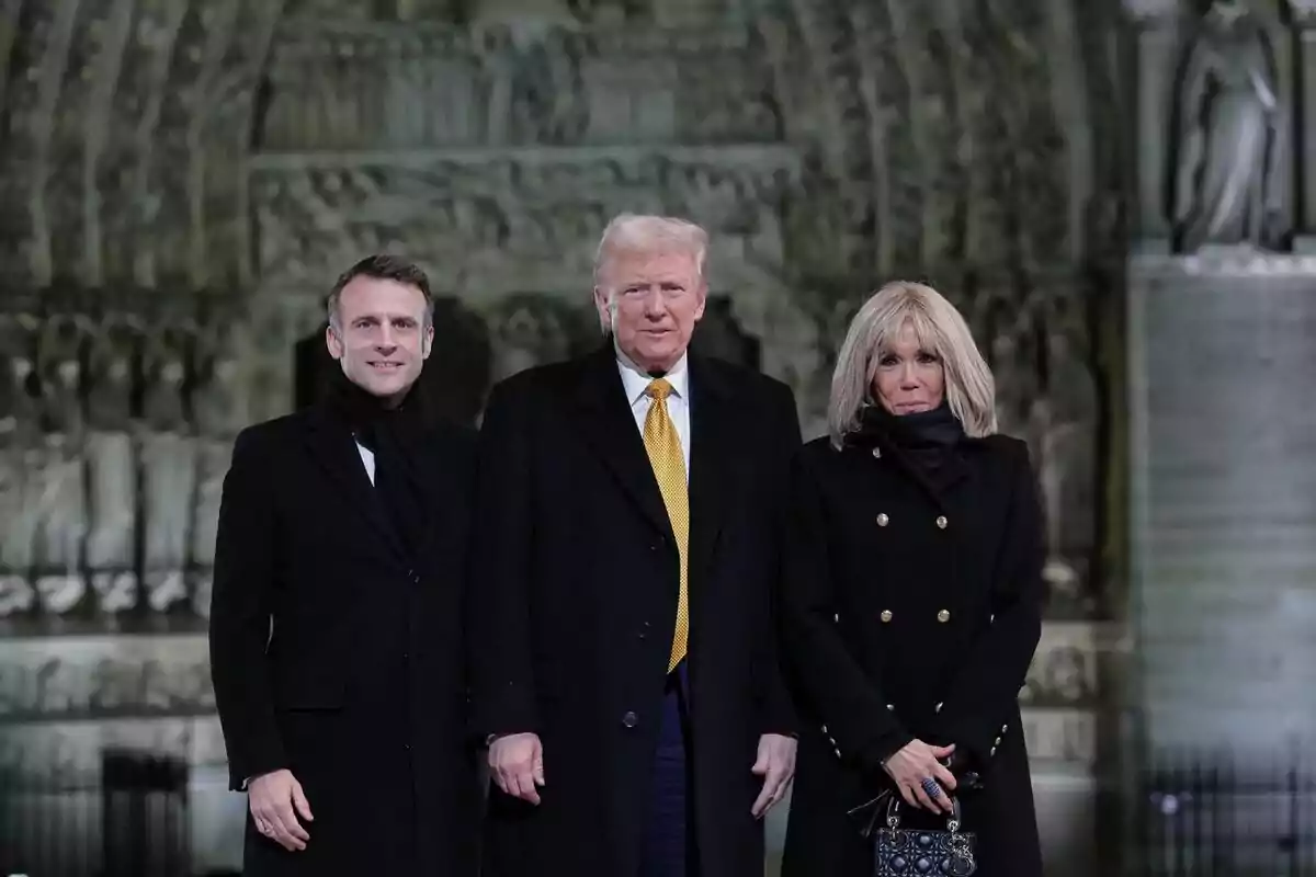 Tres personas posan juntas frente a un fondo arquitectónico detallado.