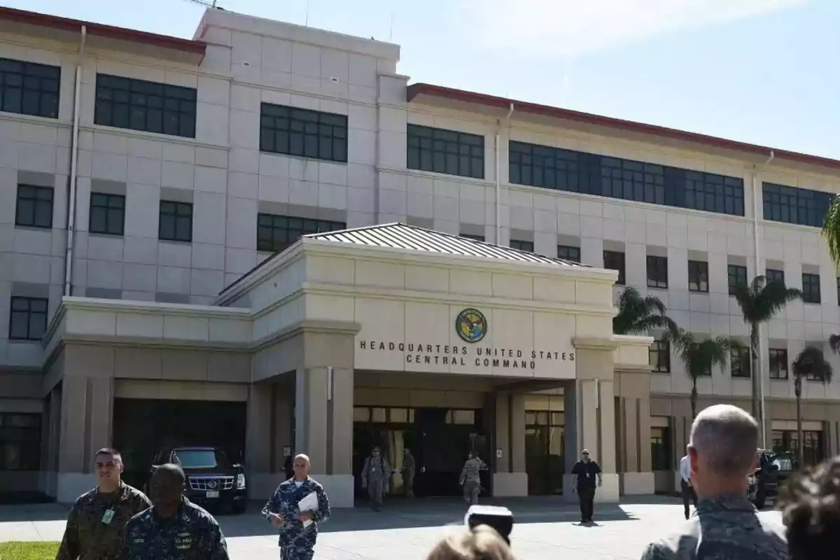 Edificio del Comando Central de los Estados Unidos con personas en uniforme militar caminando por la entrada.