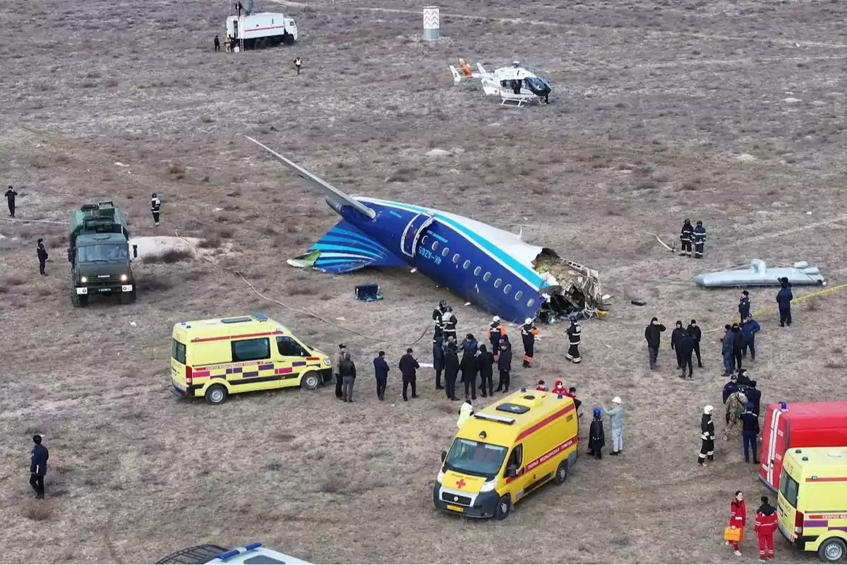 Accidente de avión en un campo con equipos de emergencia y personal de rescate presentes.