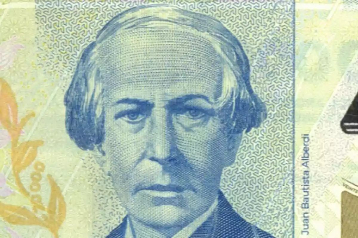 Retrato de un hombre en un billete con detalles de diseño en el fondo.