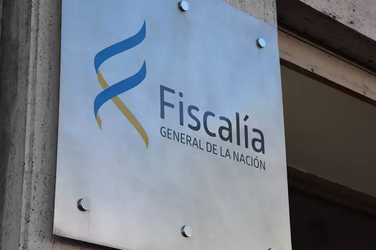 Placa metálica en la pared con el texto "Fiscalía General de la Nación" y un logotipo en azul y dorado.