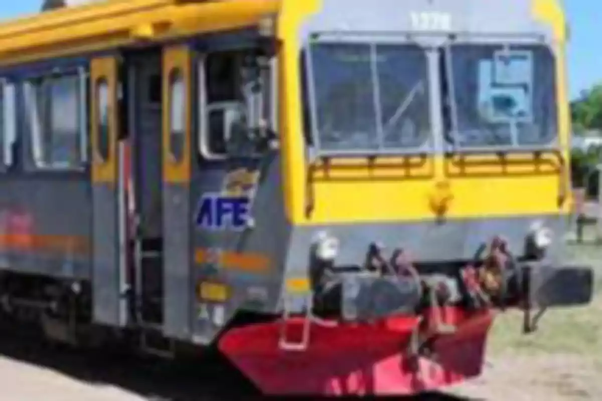 Un tren de color amarillo y gris con el logotipo de AFE en un entorno al aire libre.