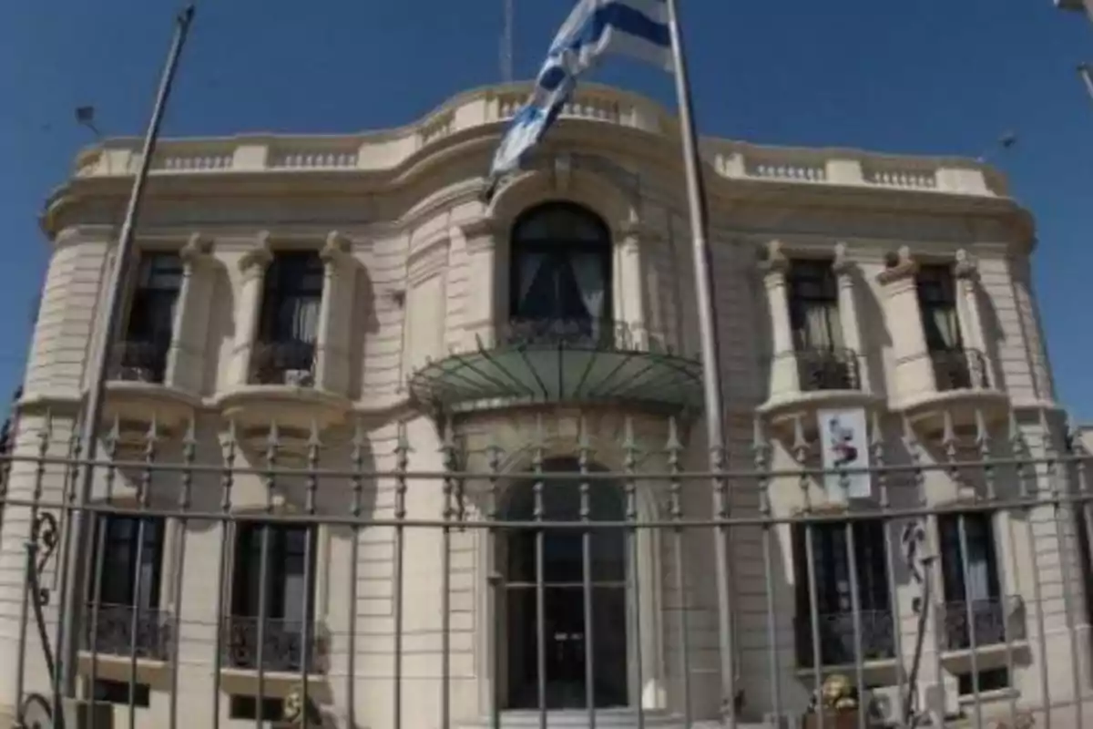 Edificio histórico de estilo clásico con una bandera ondeando al frente.