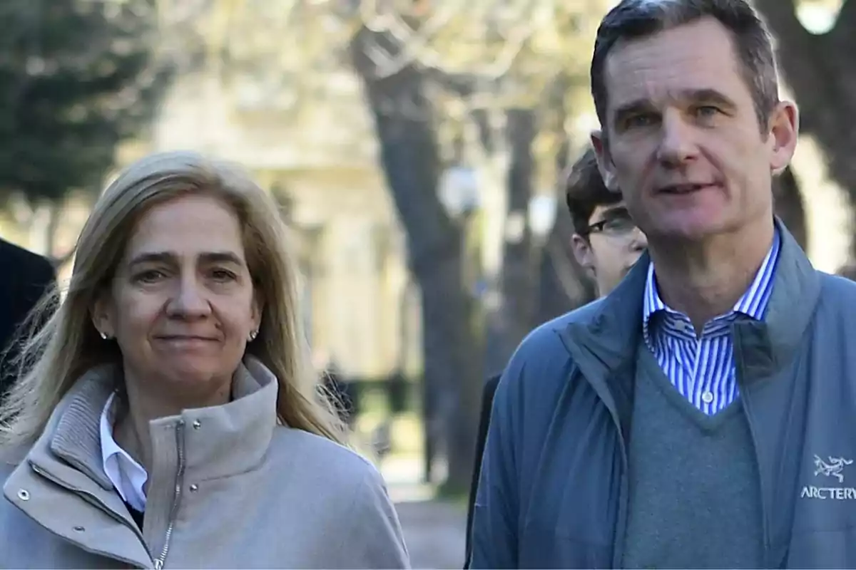 Dos personas caminando al aire libre en un entorno arbolado.