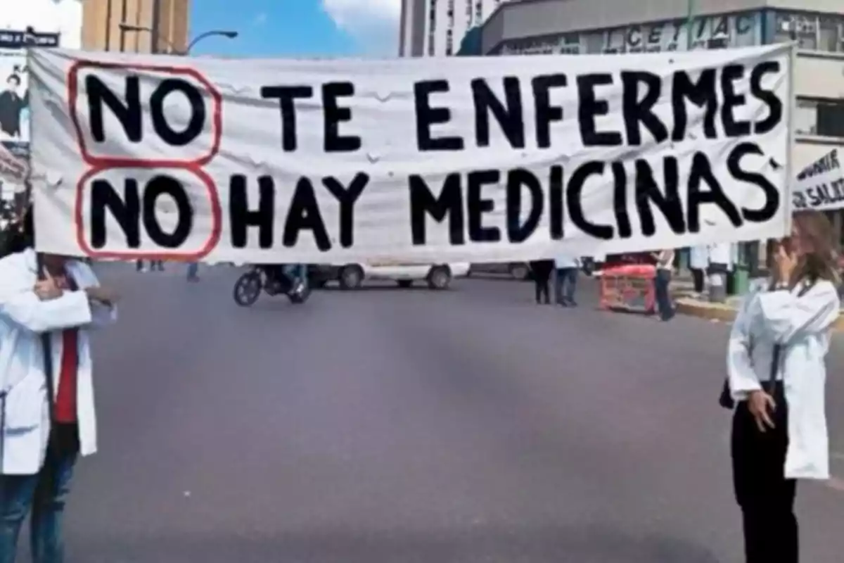 People in white coats hold a banner that says "Don't get sick, there are no medicines" on a street.