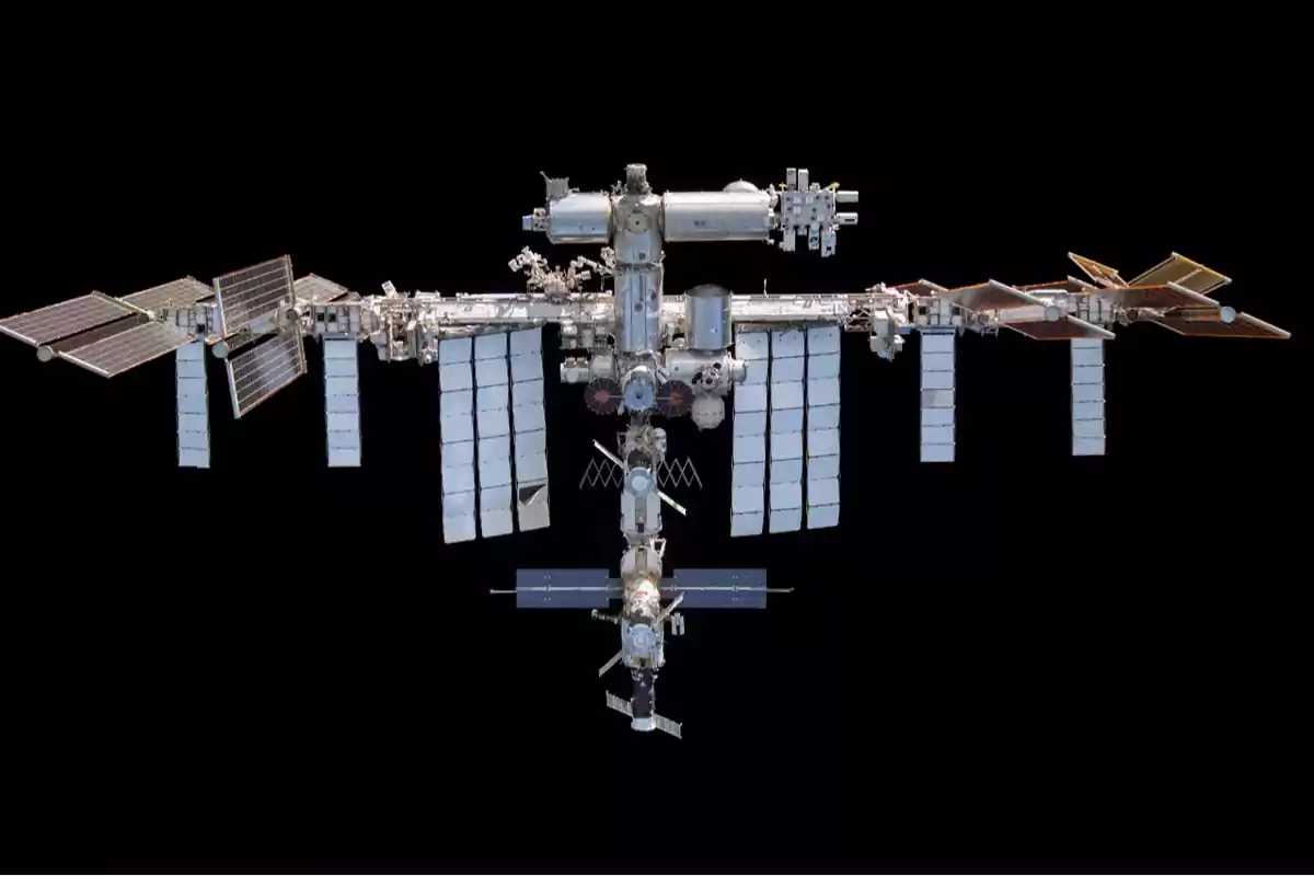 Imagen de la Estación Espacial Internacional con sus paneles solares extendidos sobre un fondo negro.