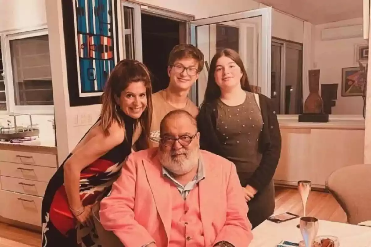 Un grupo de personas posando en una sala con decoración moderna y ventanas abiertas.