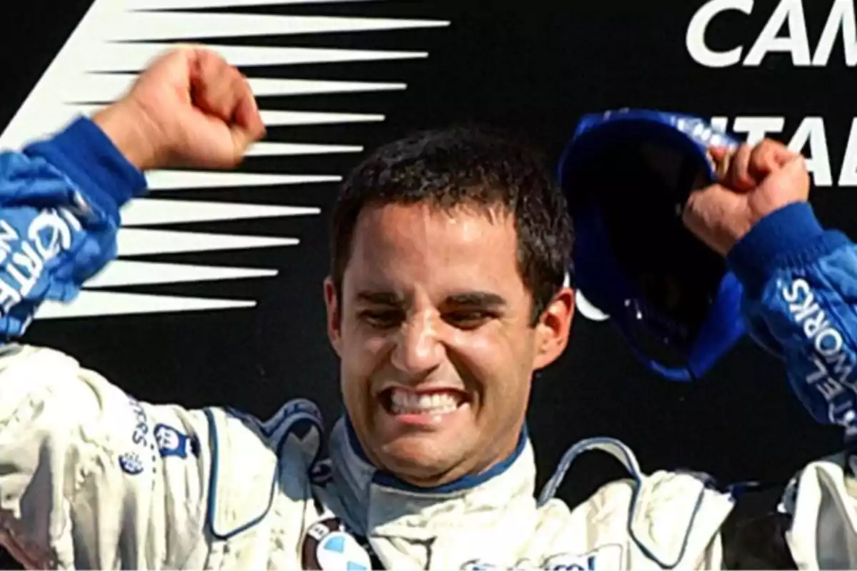 Persona celebrando con los brazos en alto y expresión de alegría, vistiendo un traje de carreras (Juan Pablo Montoya)