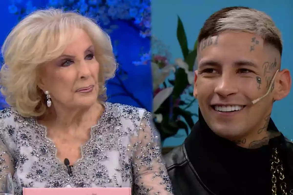 An older woman with blonde hair and an elegant dress is sitting next to a young man with visible tattoos on his face and short hair, both appear to be on a television show.