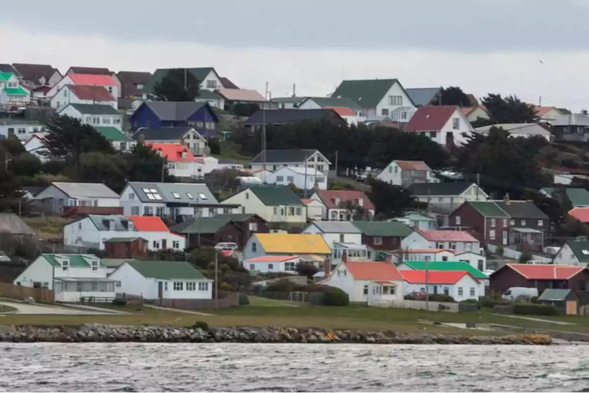 Casas coloridas en una colina junto al mar con un cielo nublado.