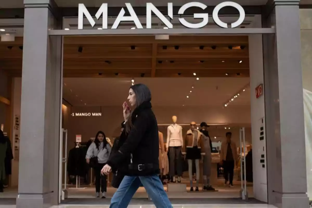 Una mujer caminando frente a una tienda de ropa 