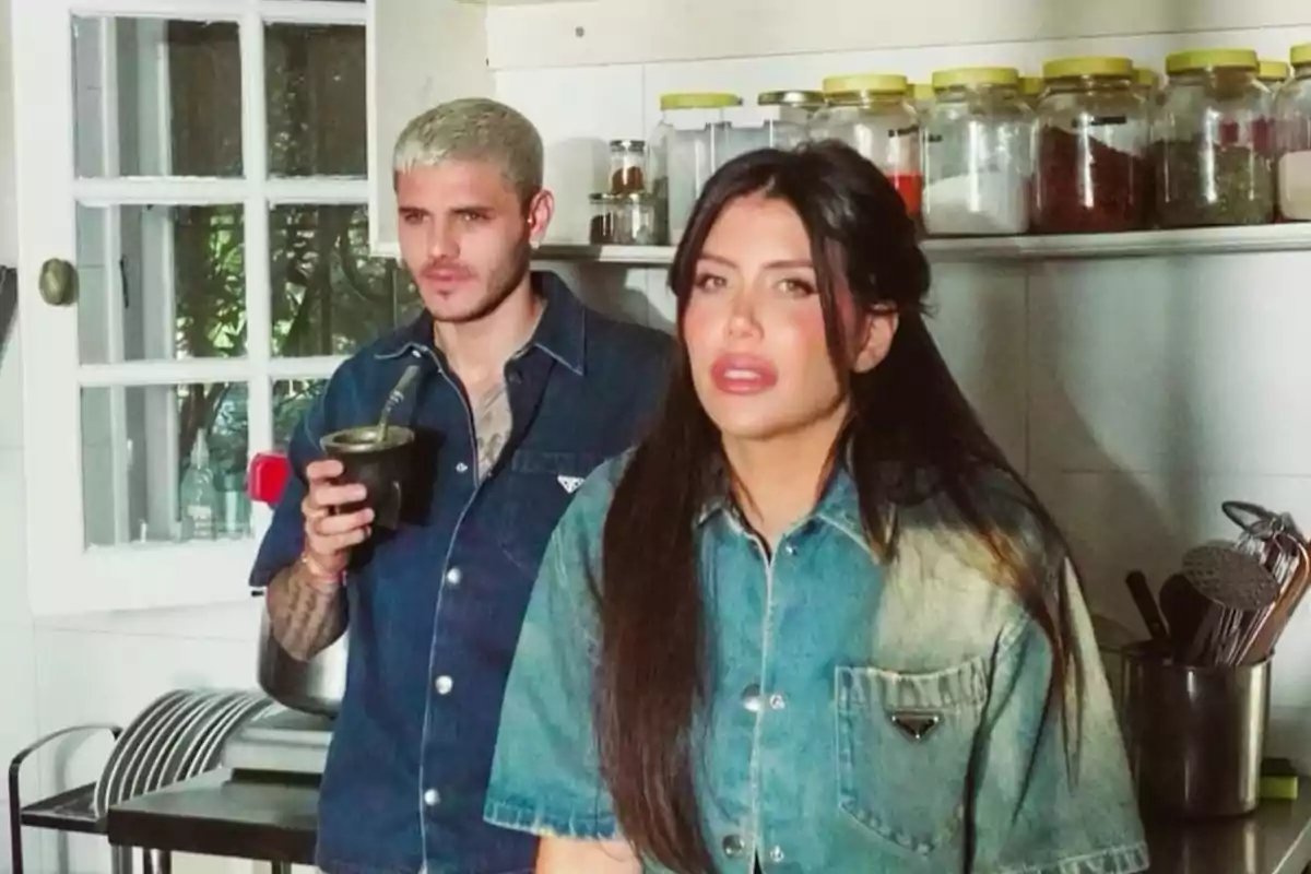 Dos personas en una cocina, una de ellas sostiene un mate.