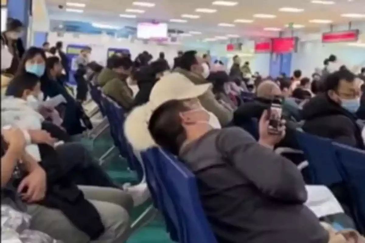 Personas sentadas en una sala de espera colapsada, muchas de ellas usando mascarillas por el brote de metapneumovirus humano en China.