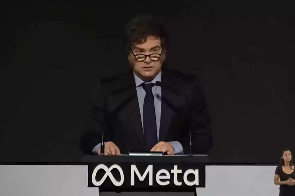 Un hombre con gafas y traje habla en un podio con el logo de Meta.