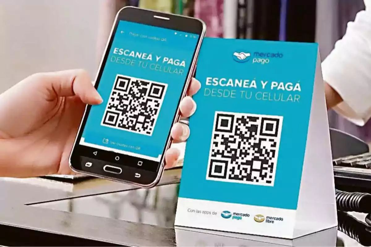 Persona escaneando un código QR con su celular para realizar un pago usando la aplicación de Mercado Pago.