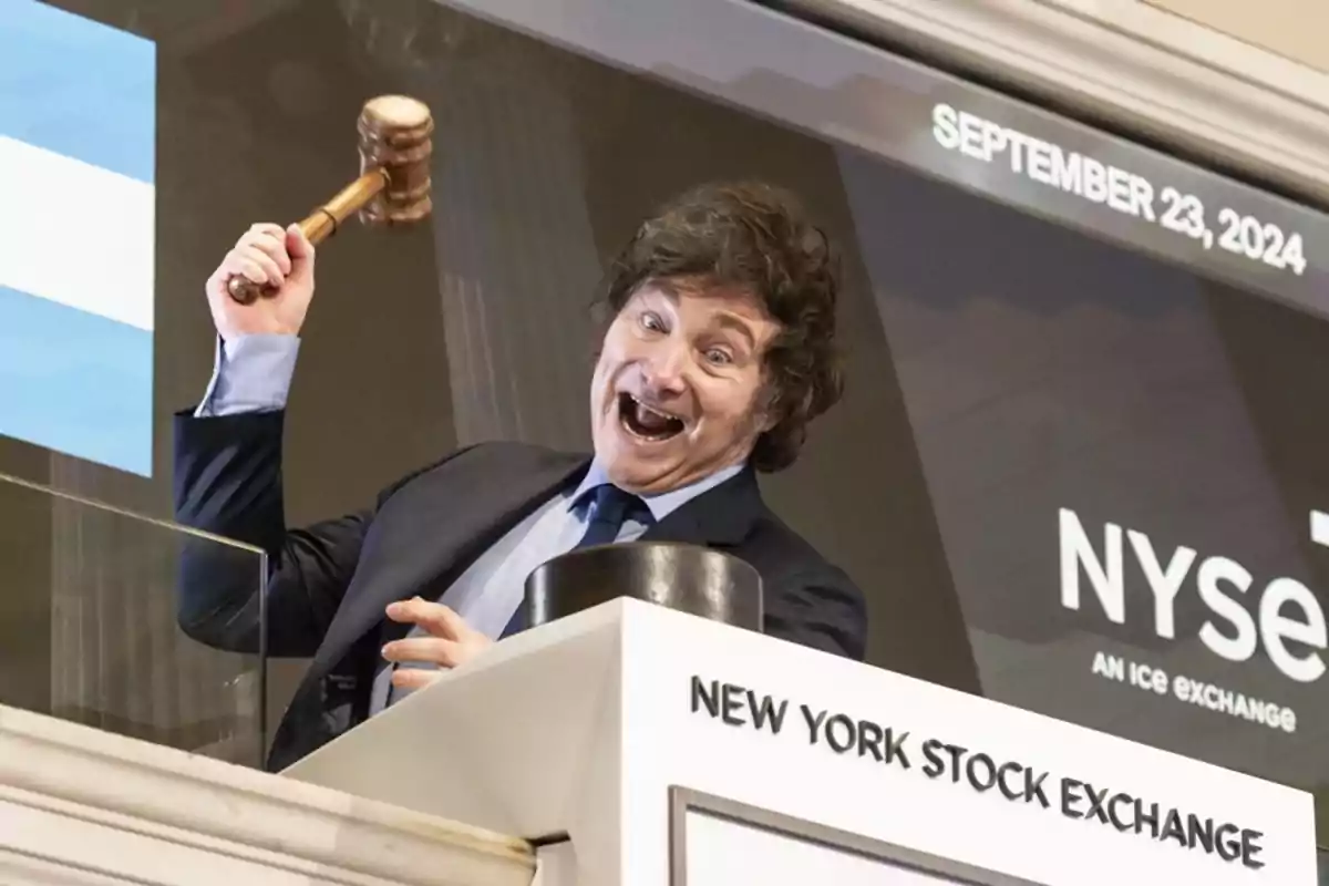 Persona sonriente levantando un mazo en el New York Stock Exchange.