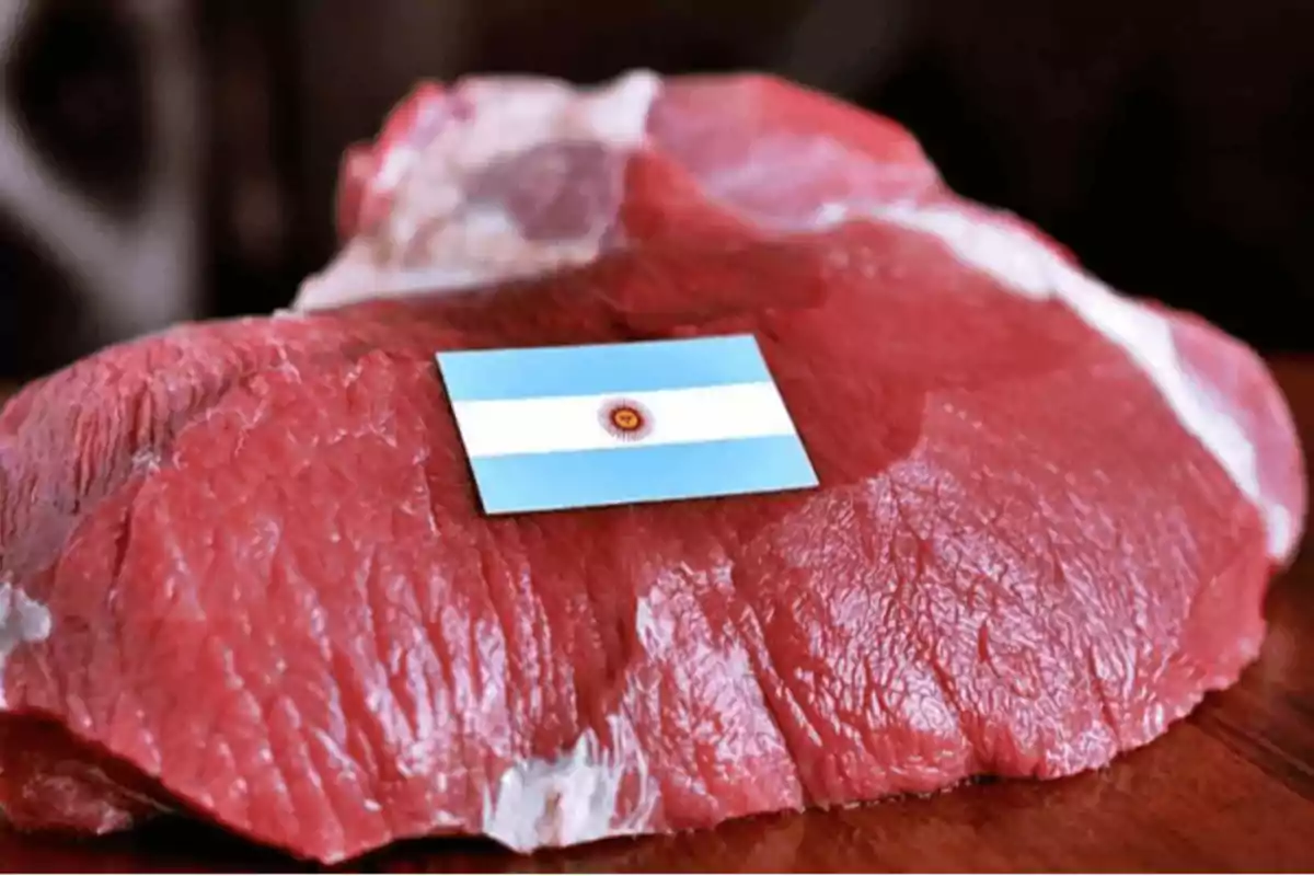 Un trozo de carne cruda con una pequeña bandera de Argentina encima.