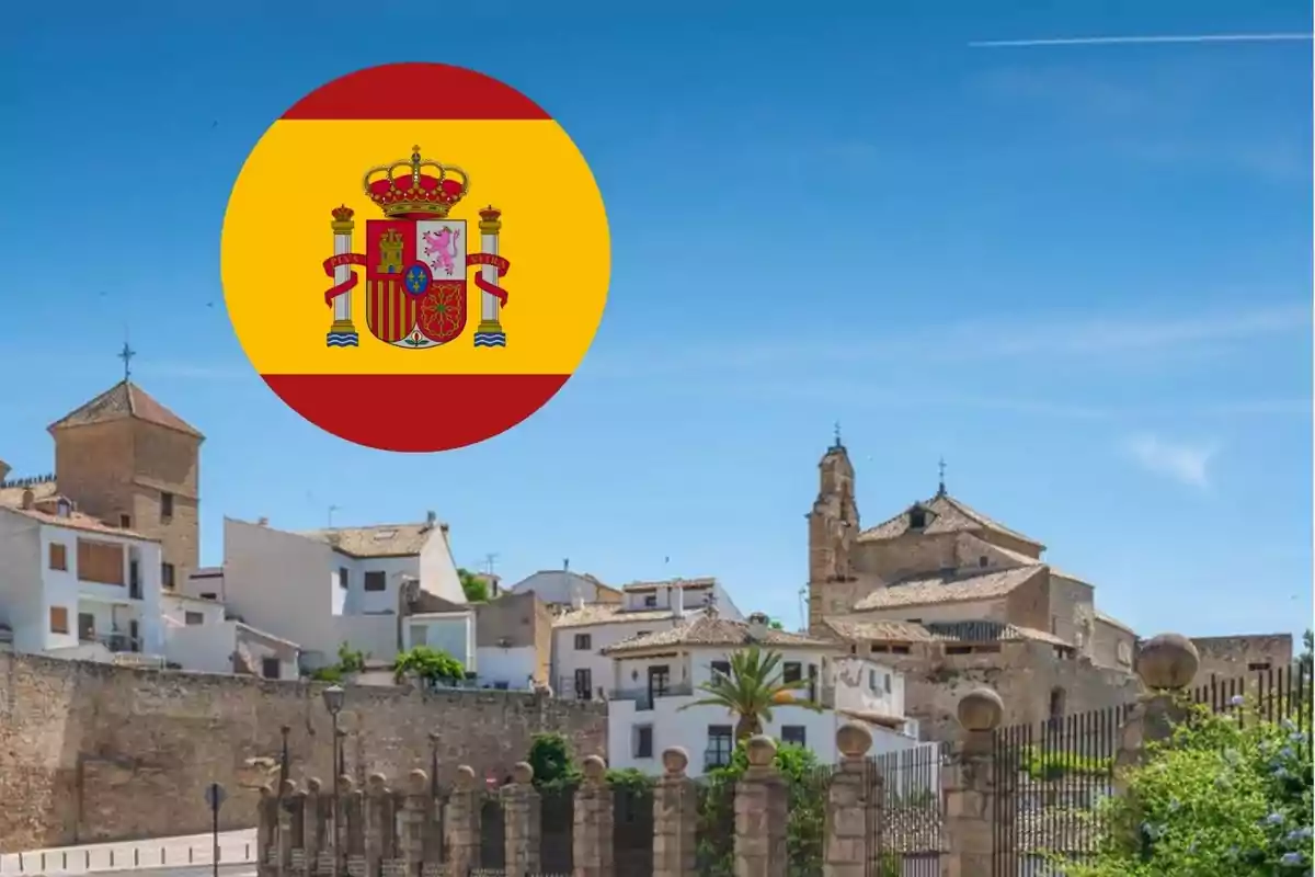 Pueblo rural histórico en donde ofrecen vivienda gratis y trabajo, con la bandera de España superpuesta en la esquina superior izquierda.