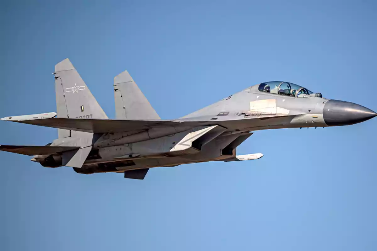 Un avión de combate volando en el cielo azul.