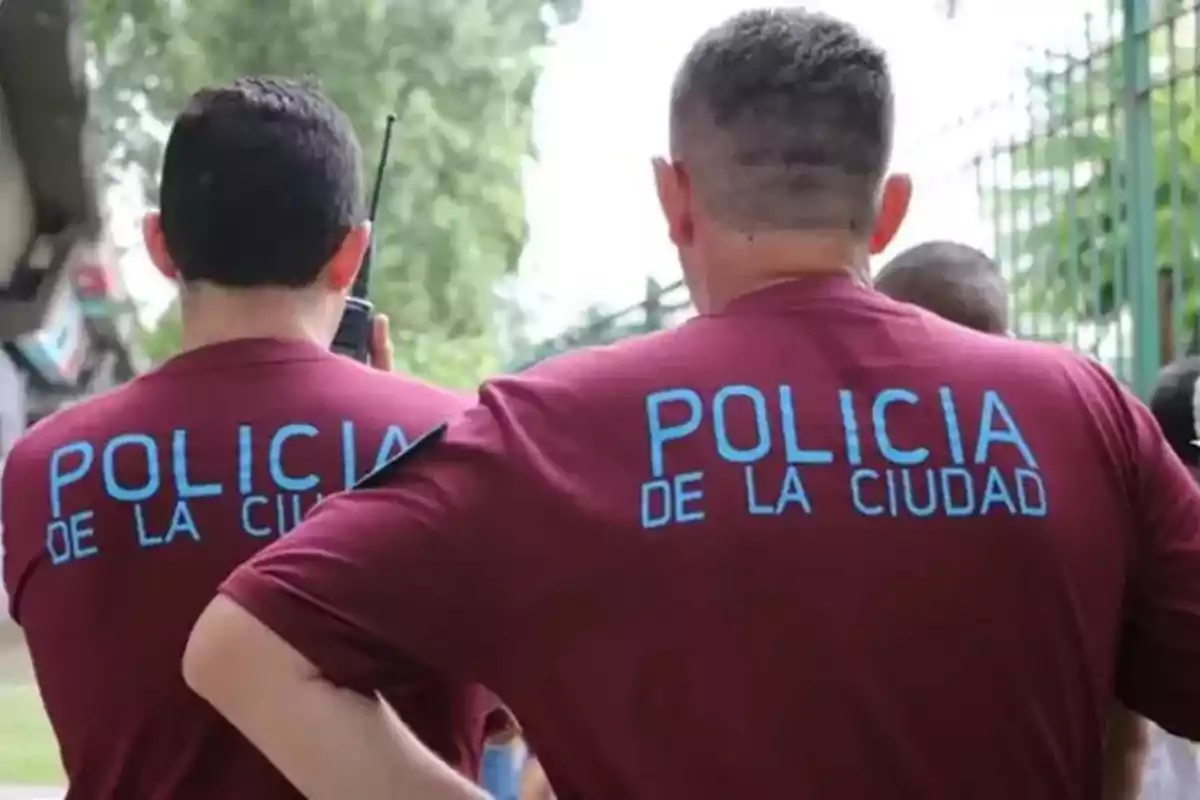 Dos personas de espaldas con camisetas que dicen 