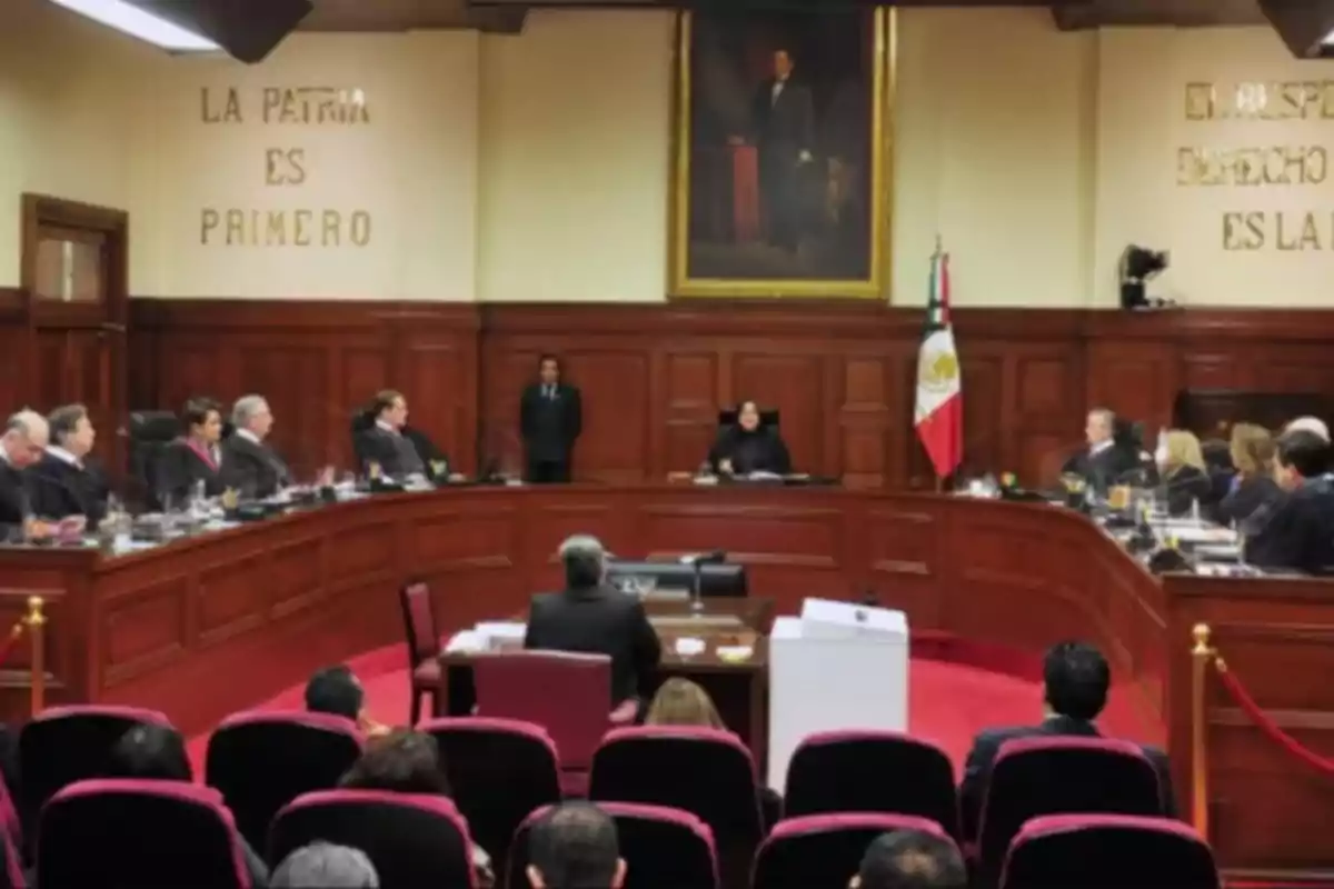 A courtroom with judges seated on a semicircular bench, a portrait on the wall, and a national flag.