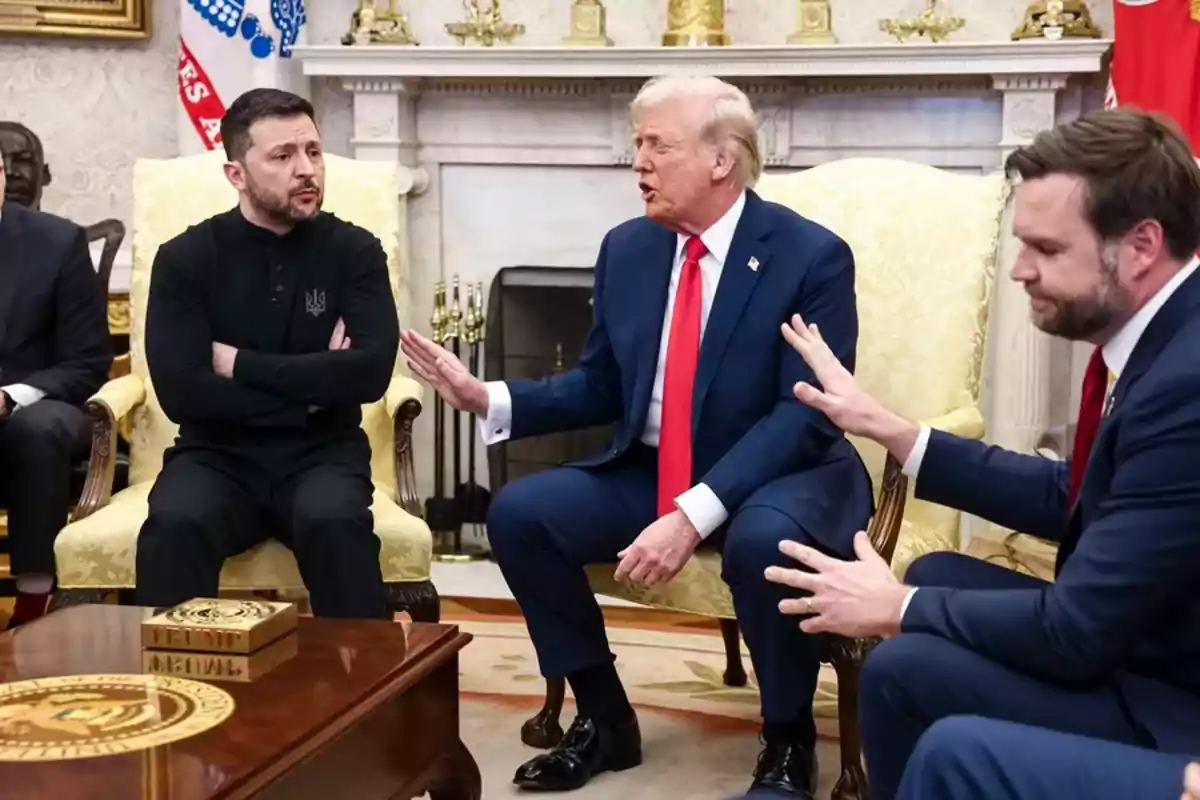 Un grupo de personas sentadas en una sala elegante, conversando de manera seria.