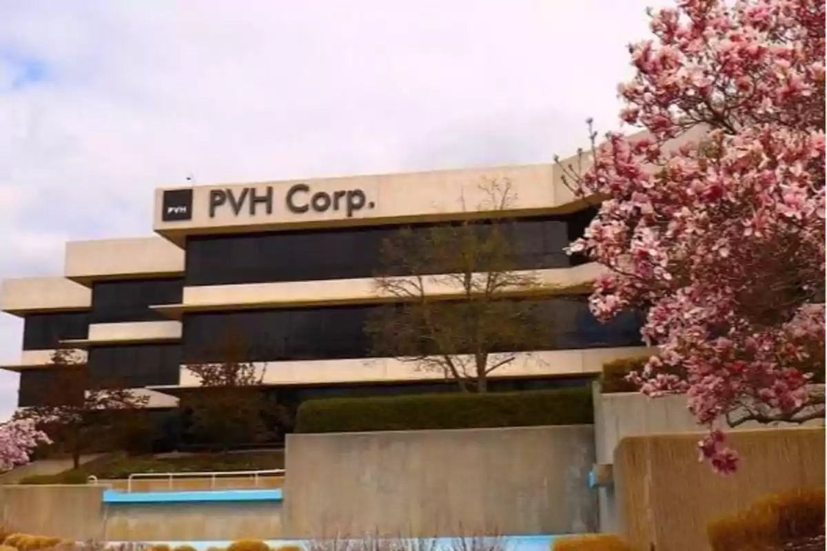 Edificio de oficinas de PVH Corp. rodeado de árboles en flor.