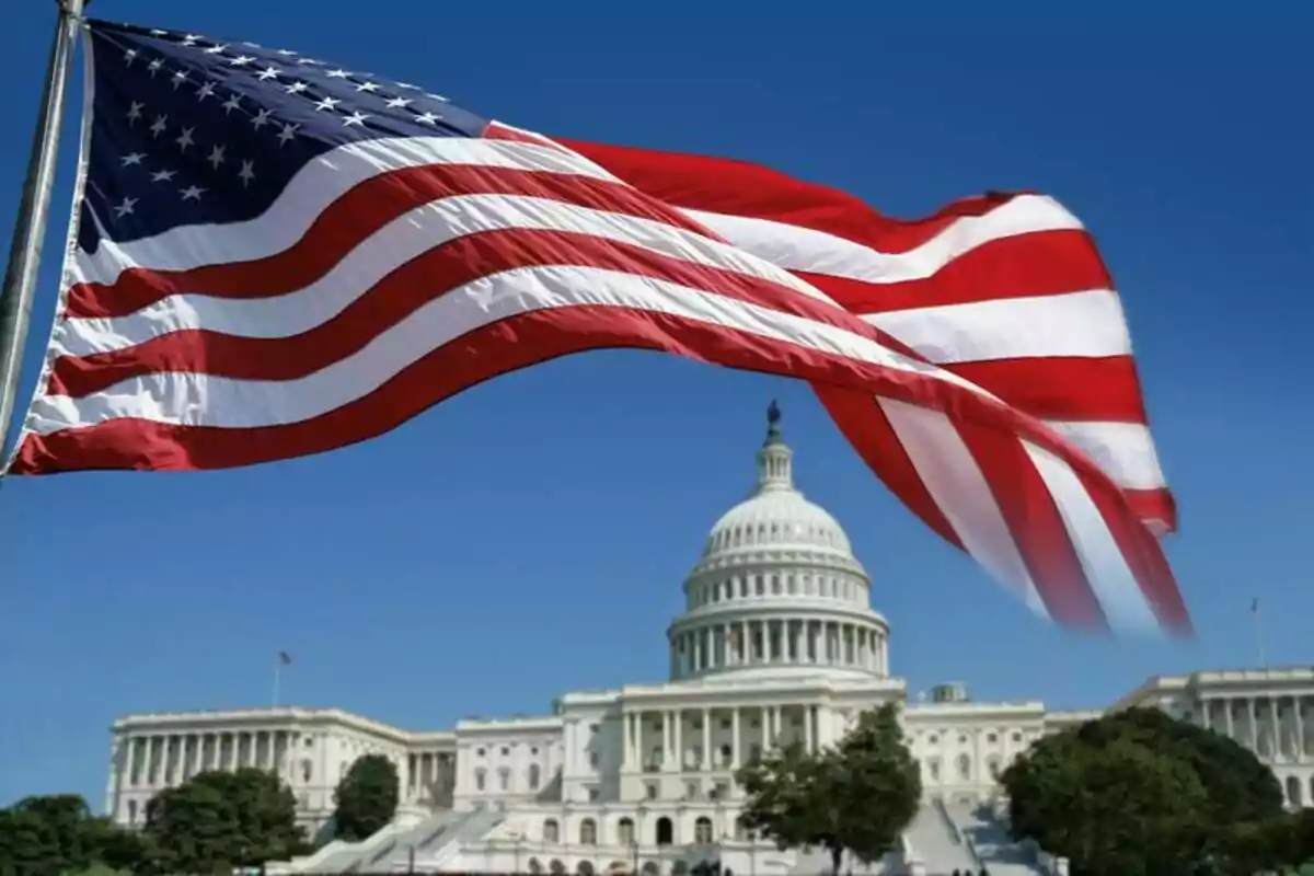 Bandera de Estados Unidos ondeando frente al edificio del Capitolio en Washington D.C.