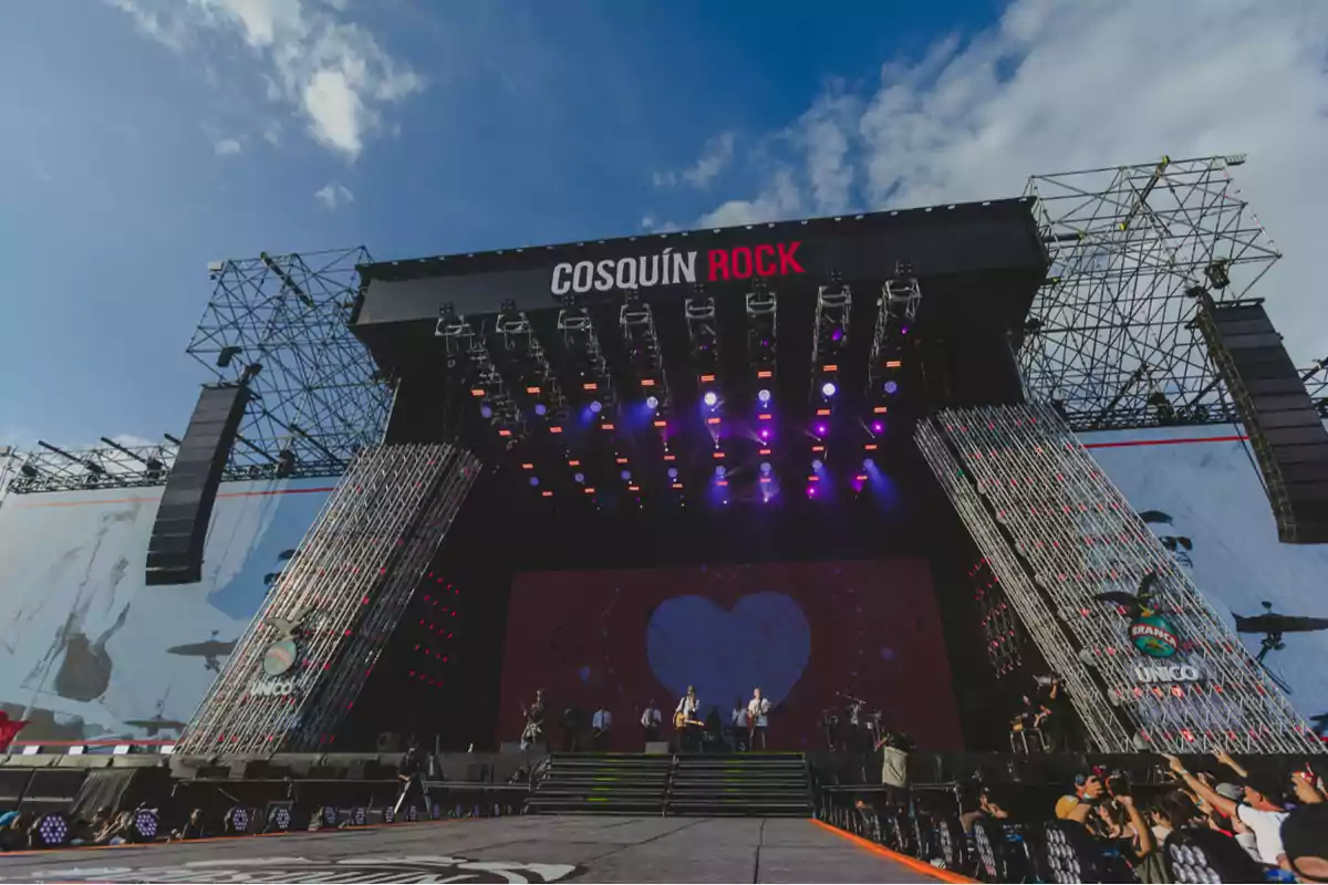 Escenario principal del festival Cosquín Rock con luces y músicos tocando en vivo bajo un cielo despejado.