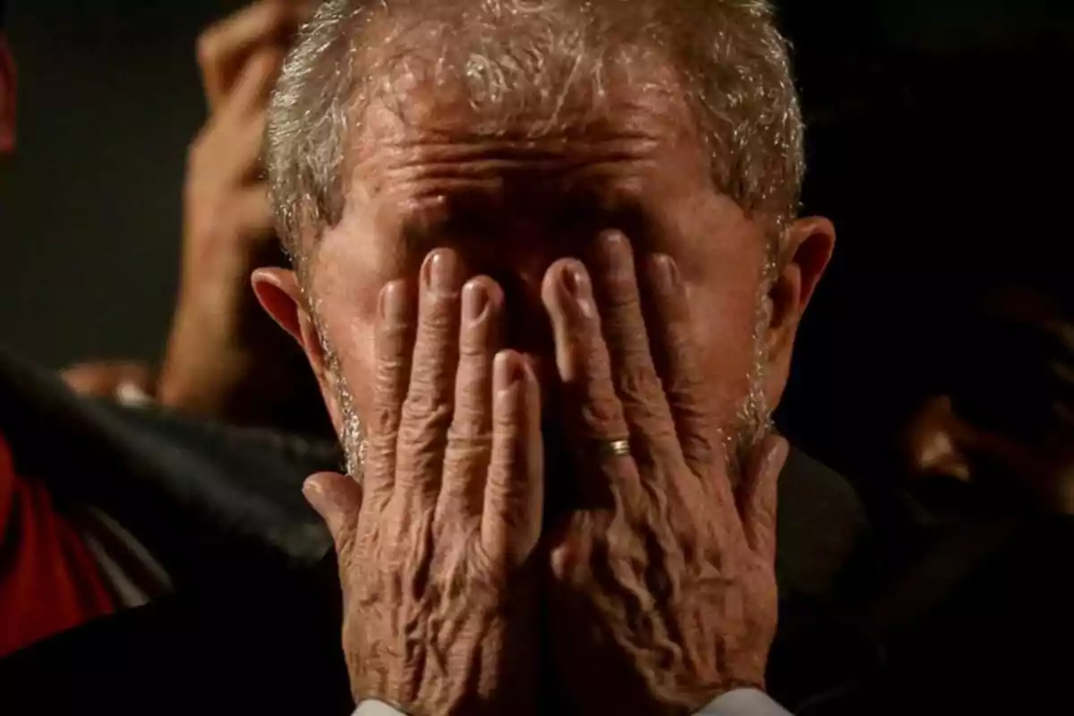 Un hombre con las manos cubriendo su rostro en un gesto de emoción o preocupación.