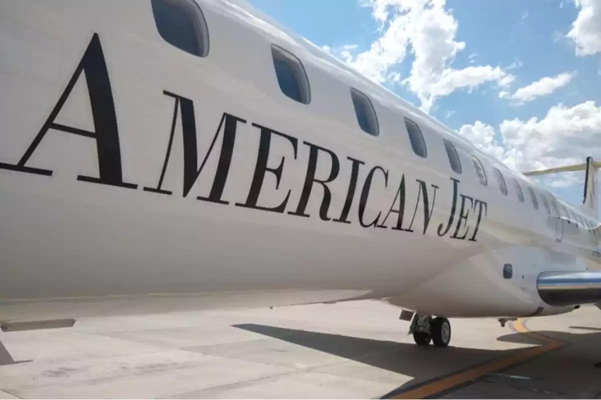 Avión de pasajeros en la pista con el texto "American Jet" en el fuselaje.