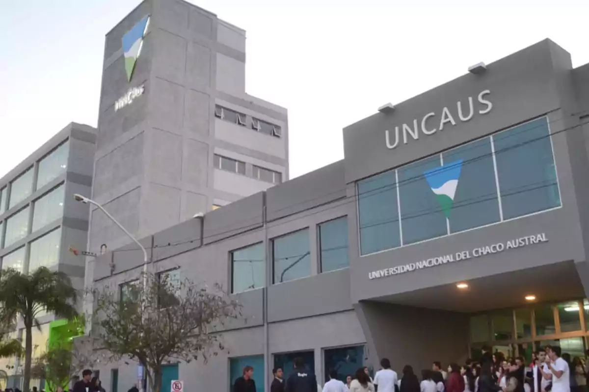 Edificio de la Universidad Nacional del Chaco Austral con personas reunidas en la entrada.