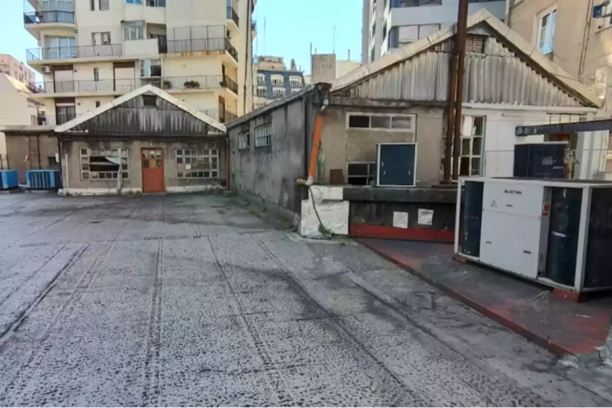 Un patio de concreto con edificios antiguos y modernos al fondo.