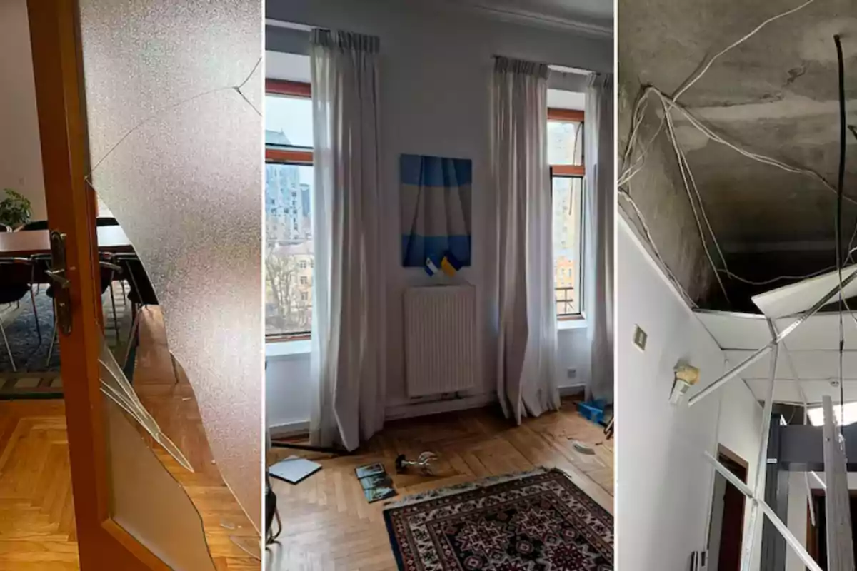 La imagen muestra una puerta de vidrio rota, una habitación con cortinas blancas y una bandera en la pared, y un techo con cables expuestos y paneles caídos.