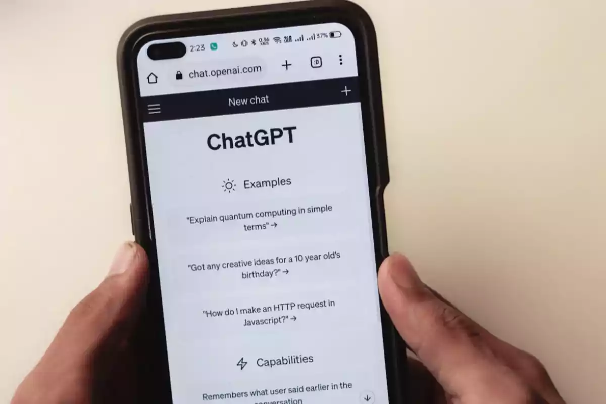 Persona sosteniendo un teléfono móvil que muestra la interfaz de ChatGPT en la pantalla.