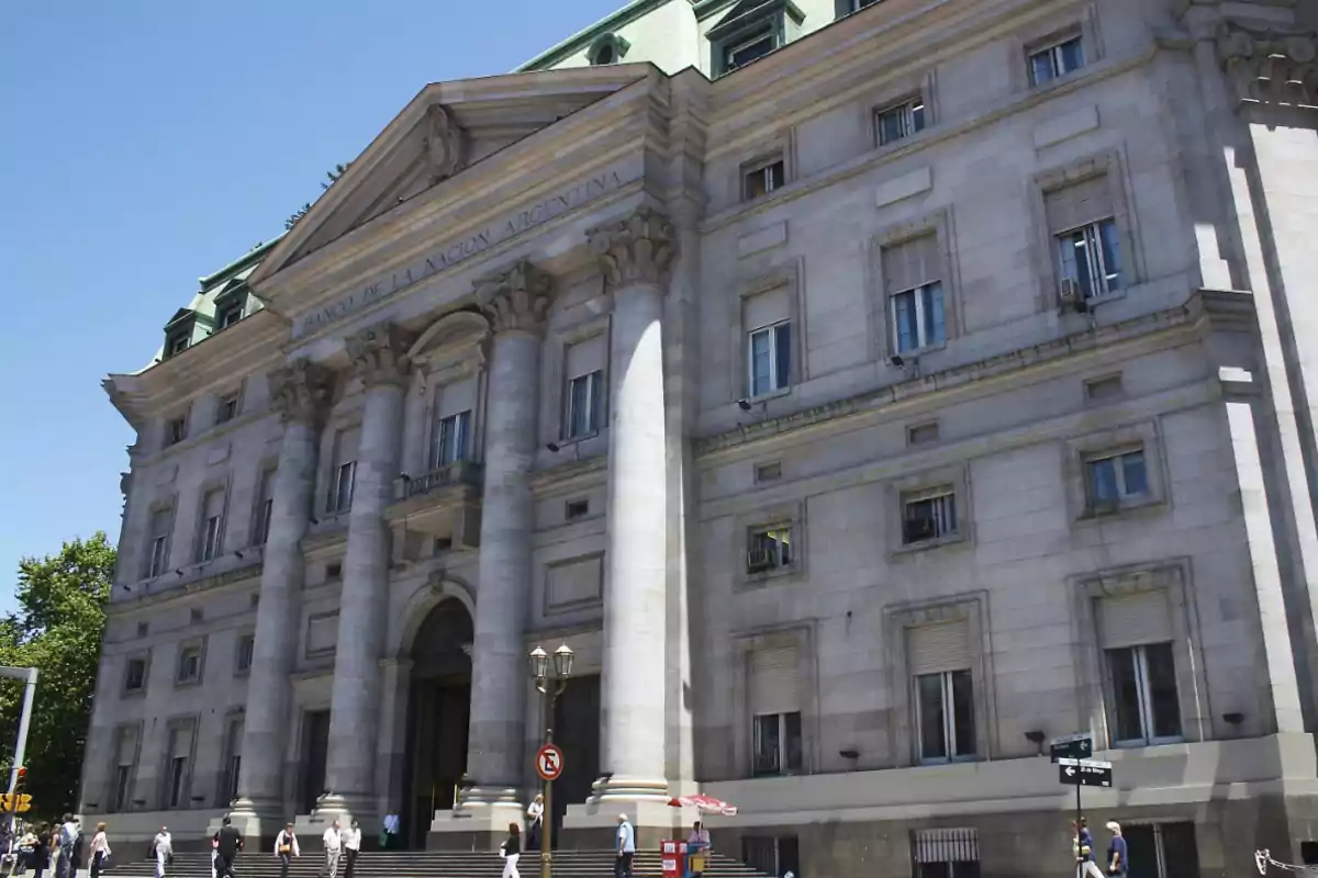 Edificio del Banco de la Nación Argentina con columnas y personas caminando al frente.