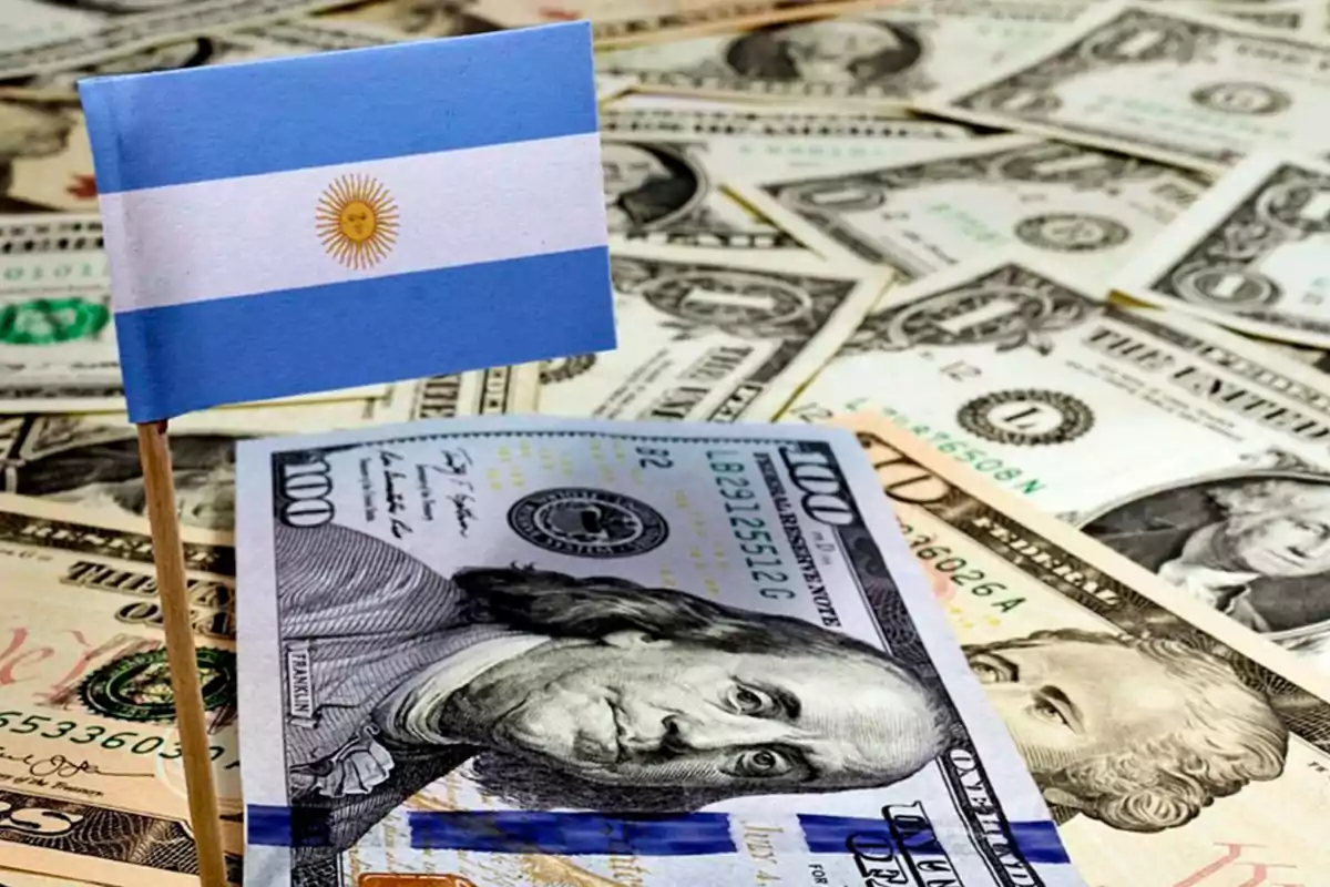 Una bandera de Argentina sobre billetes de dólares estadounidenses.