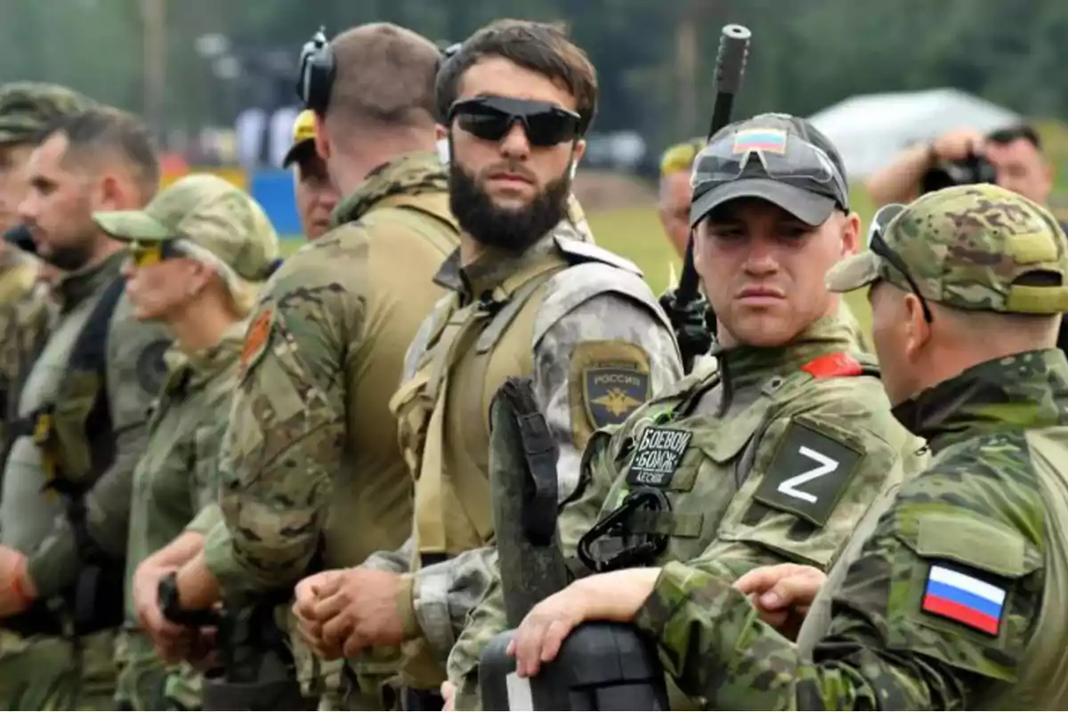 Un grupo de personas vestidas con uniformes militares y equipo táctico en un entorno al aire libre.