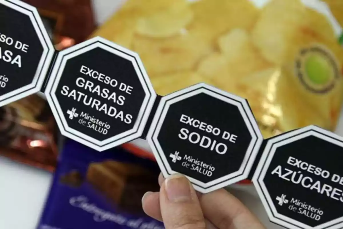 Etiquetas octagonales de advertencia sobre exceso de grasas saturadas, sodio y azúcares en productos alimenticios.