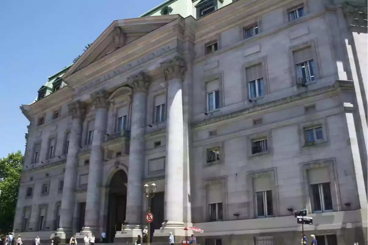 Edificio histórico con columnas y fachada clásica en un día soleado.