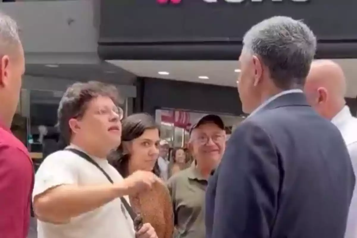 A group of people talking in a shopping mall.