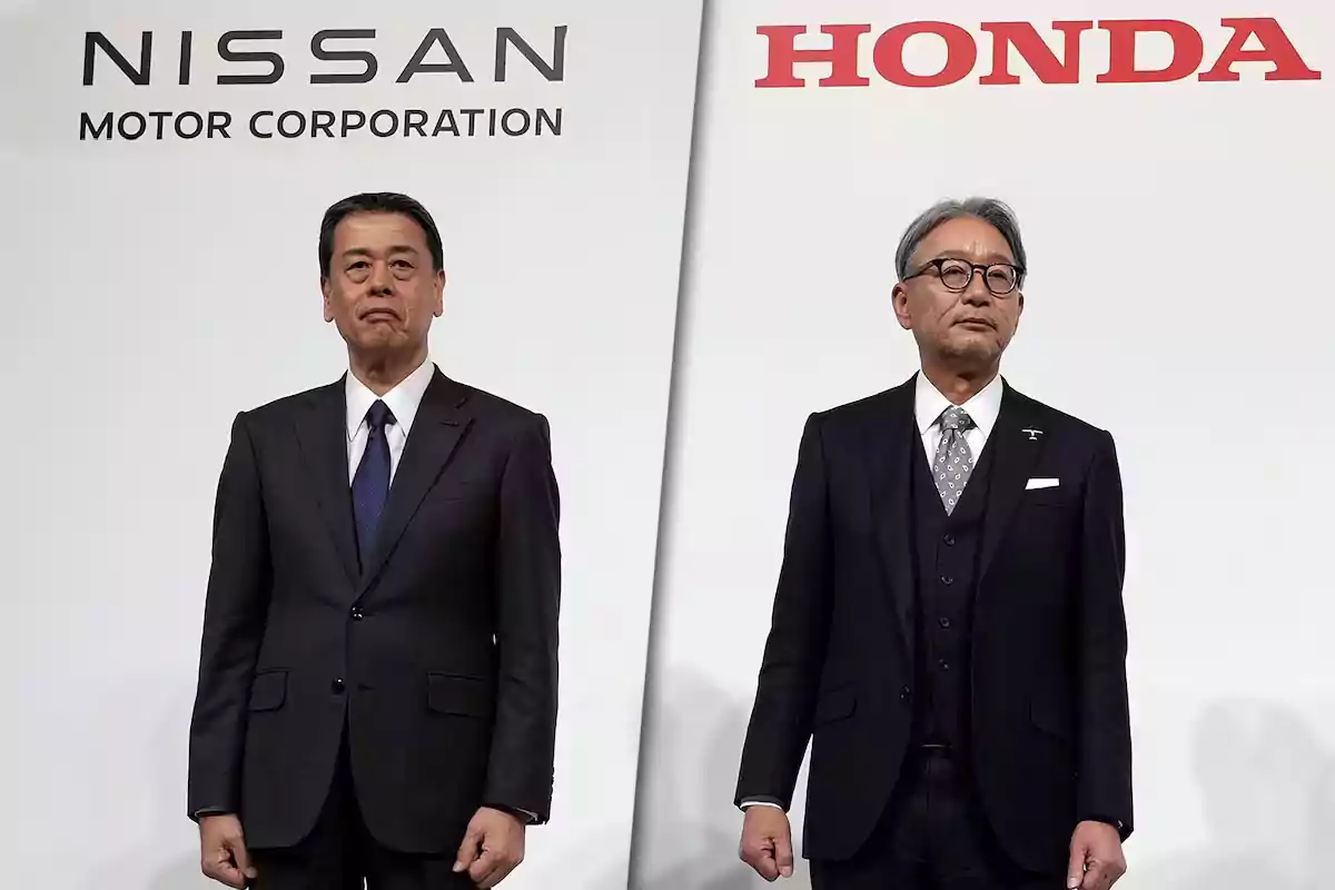 Two men in suits pose in front of the Nissan and Honda logos.