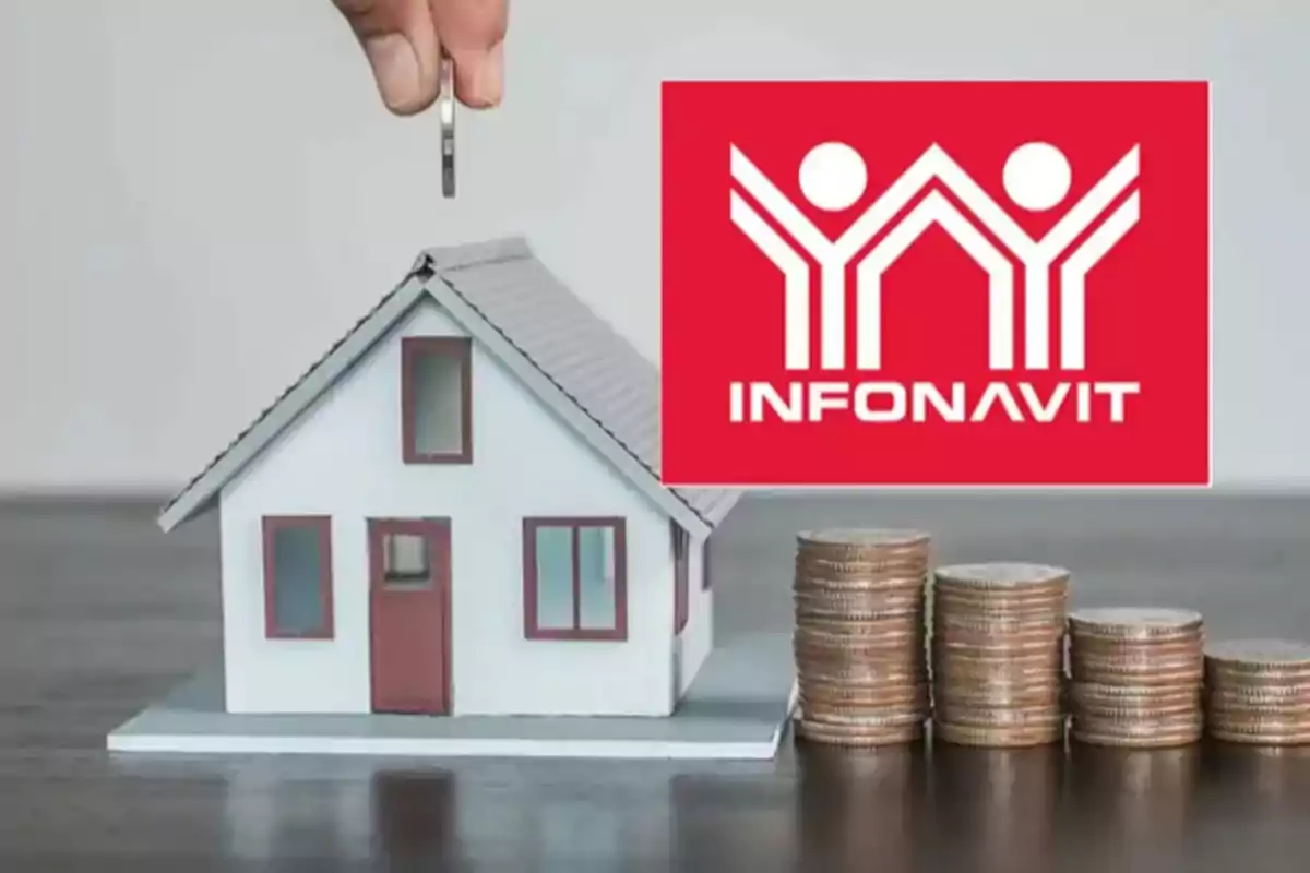 A hand places a coin on the roof of a miniature house next to stacks of coins and the Infonavit logo.