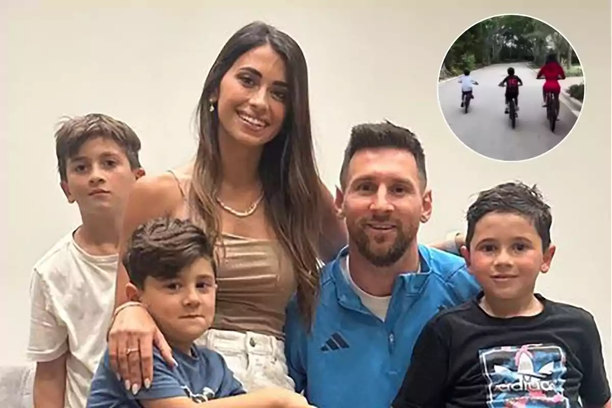 Una familia sonriente posa para una foto en un ambiente interior con un recuadro que muestra a tres personas andando en bicicleta por un camino.