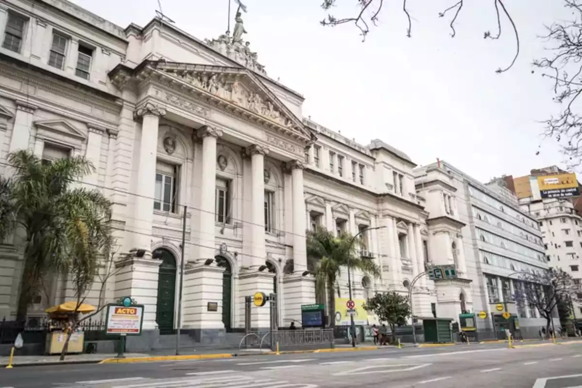 Edificio histórico con columnas y detalles arquitectónicos clásicos en una calle urbana.