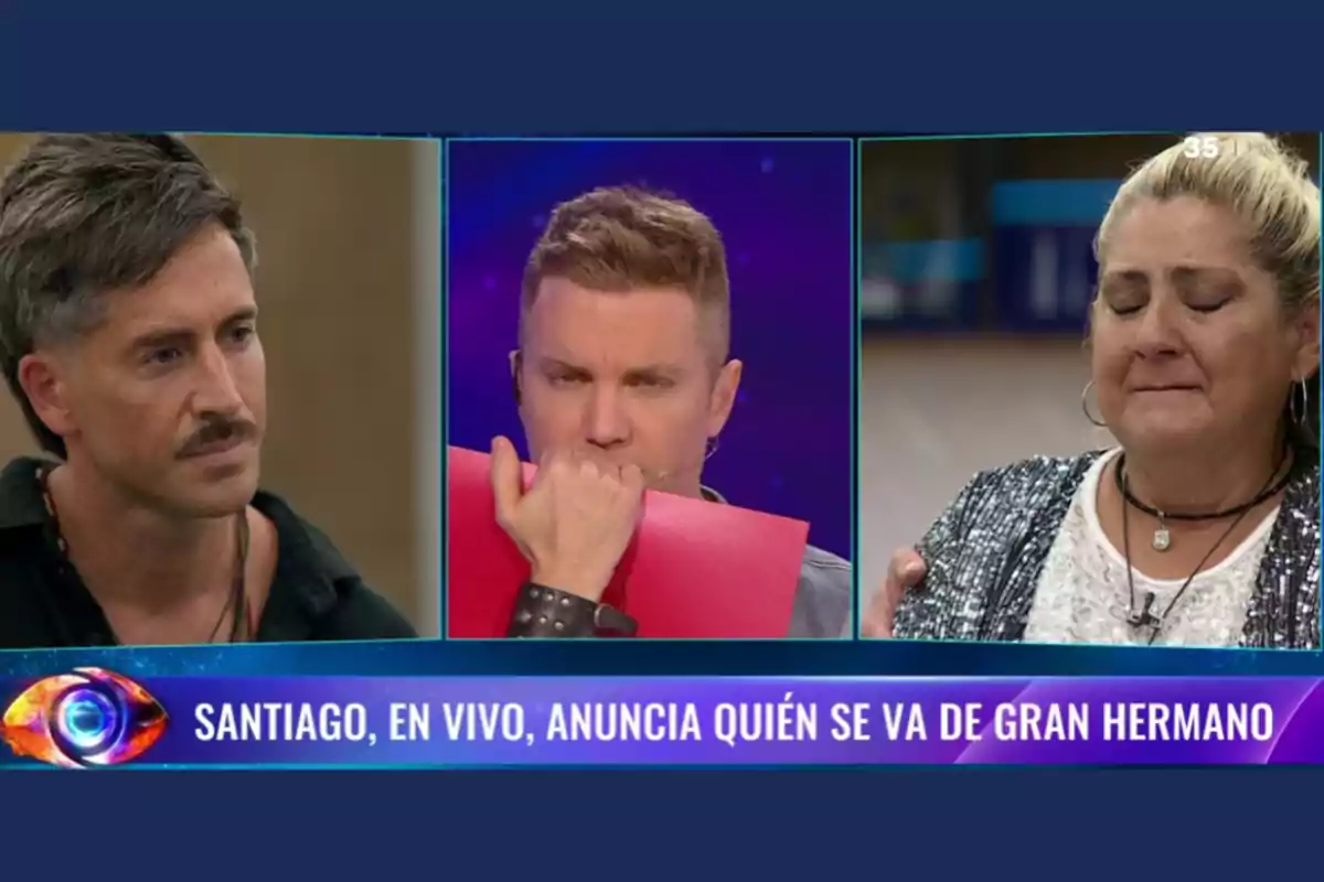 Tres personas en un programa de televisión, una de ellas sostiene un sobre rojo mientras las otras dos parecen estar esperando un anuncio importante.