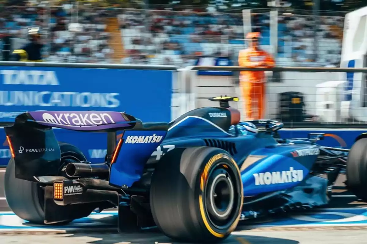 Un coche de carreras azul con logotipos de patrocinadores en un circuito de Fórmula 1.