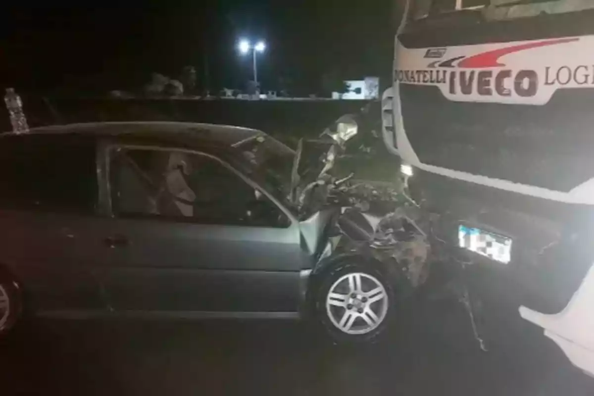 Un automóvil choca de frente contra un camión en una carretera por la noche.